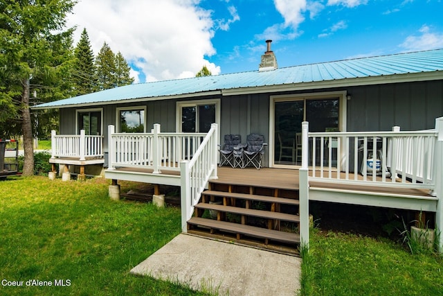 42 Bodie Ln, Priest River, ID 83856 - back of house featuring board and batten siding, a yard, a chimney, metal roof, and a wooden deck