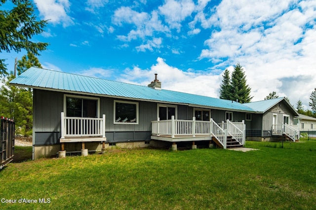 42 Bodie Ln, Priest River, ID 83856 - rear view of house featuring board and batten siding, a chimney, metal roof, and a lawn