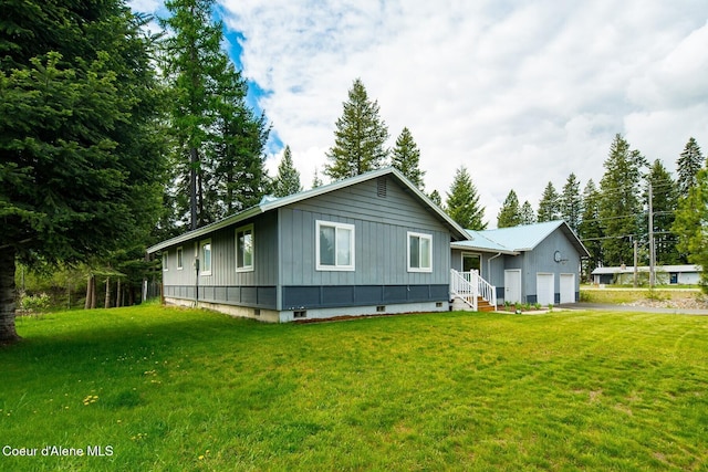 42 Bodie Ln, Priest River, ID 83856 - view of front of home featuring board and batten siding, a garage, driveway, and a front lawn