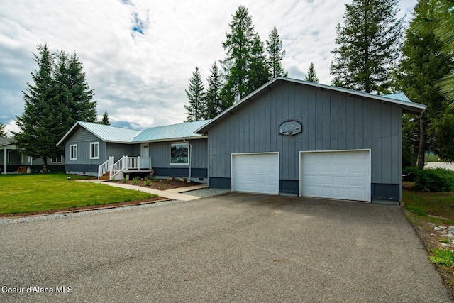 42 Bodie Ln, Priest River, ID 83856 - ranch-style home featuring metal roof, a garage, asphalt driveway, and a front lawn