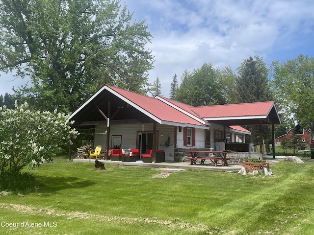 84 Highland Flats Rd, Naples, ID 83847 - back of property with a lawn, a patio area, and metal roof