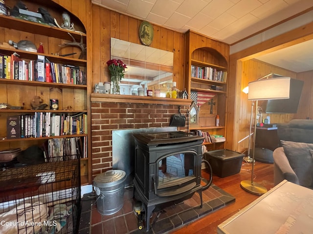 84 Highland Flats Rd, Naples, ID 83847 - living room with wooden walls, a wood stove, built in shelves, and wood finished floors