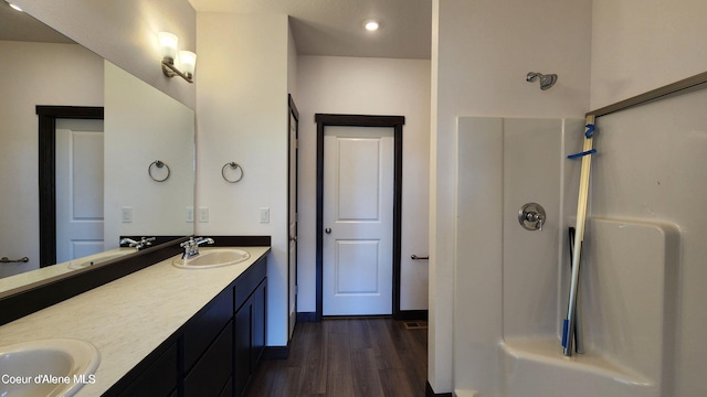 2941 N Wrenley Ln, Post Falls, ID 83854 - bathroom featuring wood finished floors, double vanity, a shower, and recessed lighting