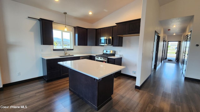 2941 N Wrenley Ln, Post Falls, ID 83854 - kitchen featuring a sink, appliances with stainless steel finishes, vaulted ceiling, light countertops, and a center island