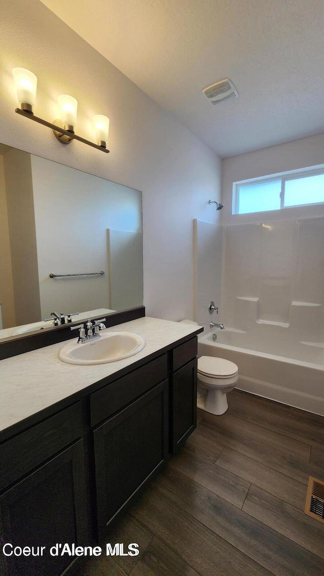 2941 N Wrenley Ln, Post Falls, ID 83854 - bathroom with toilet,  shower combination, vanity, and wood finished floors