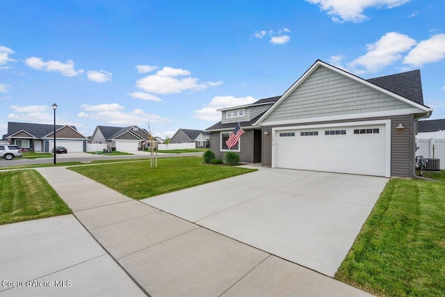 12613 N Lattner St, Rathdrum, ID 83858 - view of front of property with a garage, concrete driveway, a residential view, a front lawn, and cooling unit