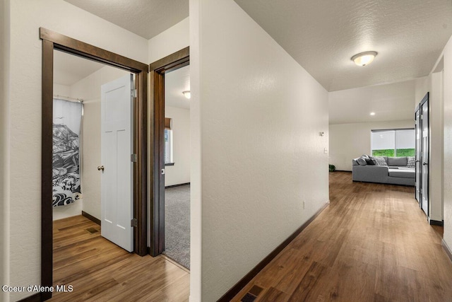 12613 N Lattner St, Rathdrum, ID 83858 - corridor with wood finished floors, baseboards, and a textured wall