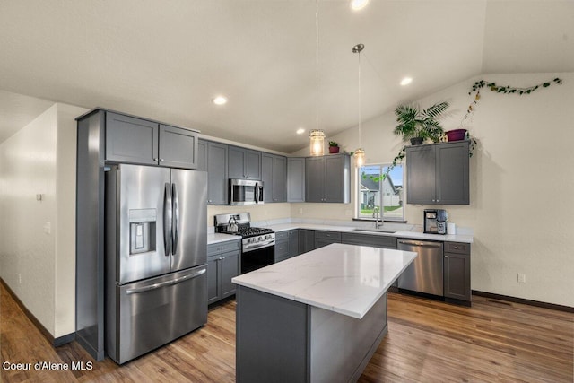 12613 N Lattner St, Rathdrum, ID 83858 - kitchen featuring appliances with stainless steel finishes, lofted ceiling, a sink, gray cabinetry, and wood finished floors