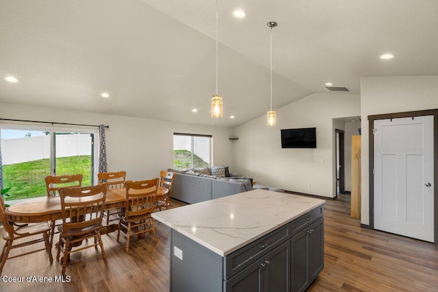 12613 N Lattner St, Rathdrum, ID 83858 - kitchen featuring lofted ceiling, dark wood finished floors, a kitchen island, decorative light fixtures, and open floor plan