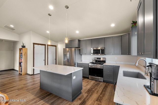 12613 N Lattner St, Rathdrum, ID 83858 - kitchen with stainless steel appliances, a sink, light stone countertops, gray cabinets, and vaulted ceiling