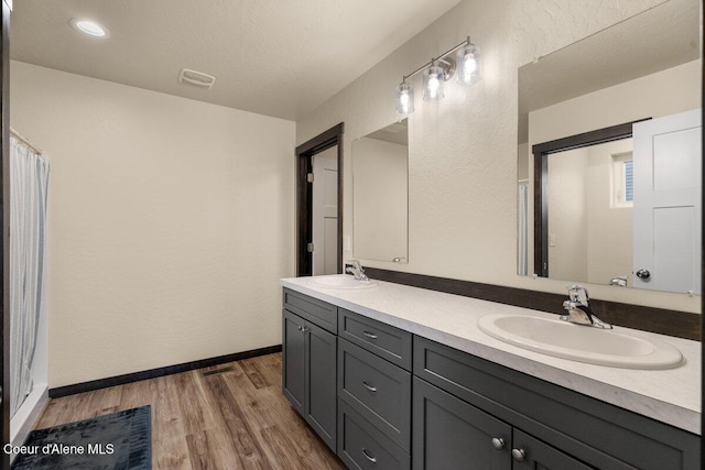 12613 N Lattner St, Rathdrum, ID 83858 - full bathroom with wood finished floors, double vanity, baseboards, and a shower with shower curtain