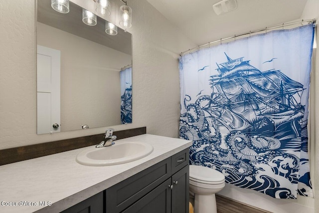 12613 N Lattner St, Rathdrum, ID 83858 - full bath featuring vanity, toilet, a textured wall, a shower with shower curtain, and wood finished floors