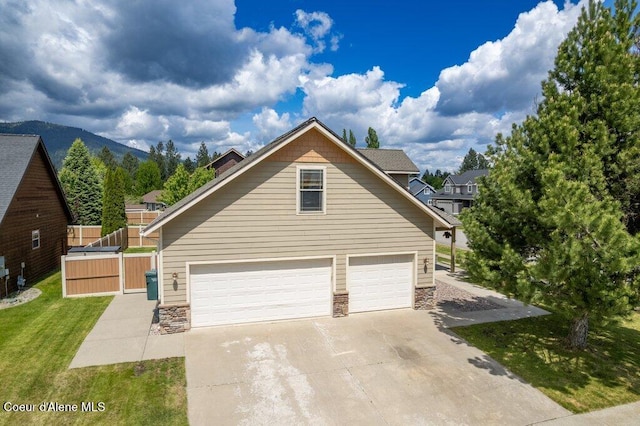 15360 N Nixon Loop, Rathdrum, ID 83858 - view of side of home featuring stone siding, driveway, and an attached garage
