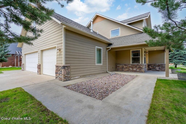 15360 N Nixon Loop, Rathdrum, ID 83858 - view of front of property featuring stone siding, driveway, covered porch, and a shingled roof