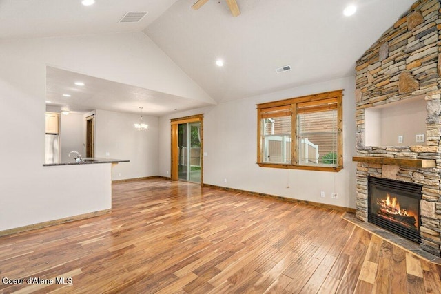 15360 N Nixon Loop, Rathdrum, ID 83858 - unfurnished living room featuring a fireplace, a chandelier, light wood-type flooring, high vaulted ceiling, and recessed lighting