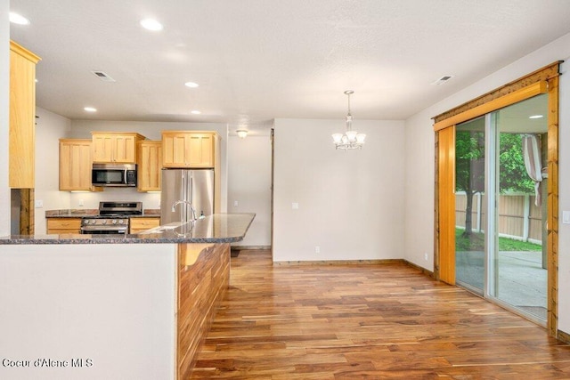15360 N Nixon Loop, Rathdrum, ID 83858 - kitchen featuring appliances with stainless steel finishes, light brown cabinetry, light wood finished floors, recessed lighting, and a chandelier
