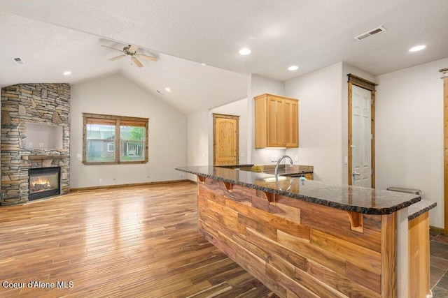 15360 N Nixon Loop, Rathdrum, ID 83858 - kitchen with a ceiling fan, a kitchen bar, wood finished floors, lofted ceiling, and light brown cabinetry