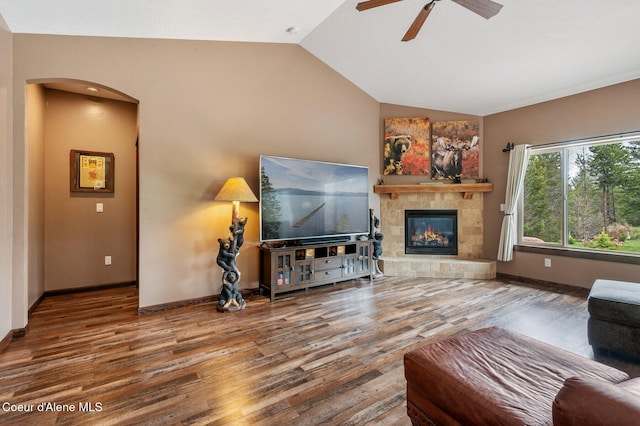 29264 N Ramsey Rd, Athol, ID 83801 - living room with wood finished floors, arched walkways, vaulted ceiling, ceiling fan, and a tile fireplace