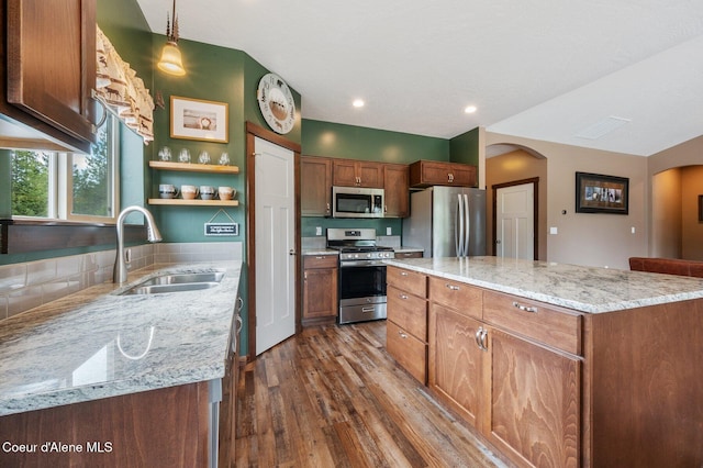 29264 N Ramsey Rd, Athol, ID 83801 - kitchen featuring stainless steel appliances, a sink, arched walkways, dark wood finished floors, and a center island