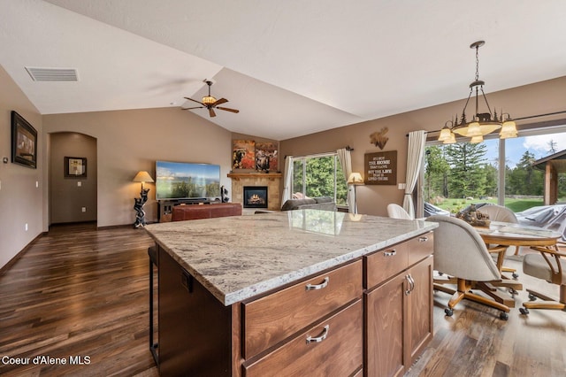 29264 N Ramsey Rd, Athol, ID 83801 - kitchen with a ceiling fan, dark wood-style flooring, lofted ceiling, a glass covered fireplace, and light stone countertops
