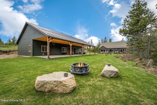 29264 N Ramsey Rd, Athol, ID 83801 - rear view of property with an outdoor fire pit, a patio area, a lawn, and metal roof