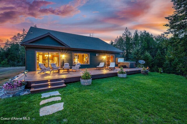 29264 N Ramsey Rd, Athol, ID 83801 - back of house at dusk with a hot tub, a lawn, and a deck