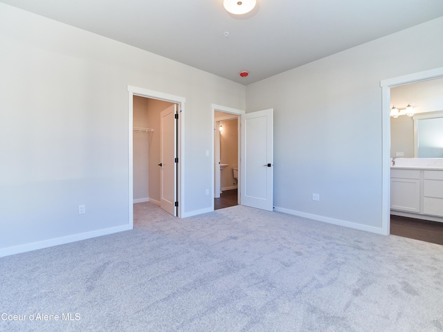 898 E Railroad Ave, Post Falls, ID 83854 - unfurnished bedroom featuring a spacious closet, dark colored carpet, baseboards, and a closet