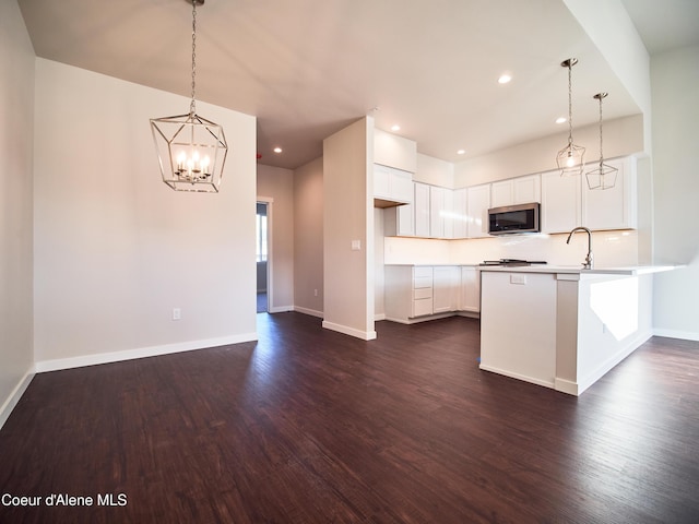 898 E Railroad Ave, Post Falls, ID 83854 - kitchen featuring stainless steel microwave, dark wood finished floors, a peninsula, a chandelier, and recessed lighting
