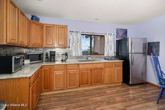 23 S Lightning Spur Ln, Coeur Dalene, ID 83814 - kitchen with appliances with stainless steel finishes, a sink, dark wood finished floors, backsplash, and brown cabinetry