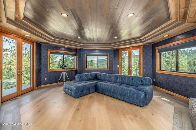 23 S Lightning Spur Ln, Coeur Dalene, ID 83814 - living area featuring french doors, wooden ceiling, wallpapered walls, a tray ceiling, and plenty of natural light