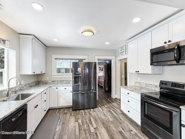 372 E Jefferson Ave, Priest River, ID 83856 - kitchen featuring appliances with stainless steel finishes, a sink, wood finished floors, white cabinets, and recessed lighting