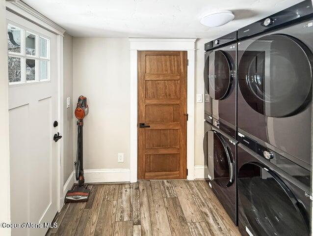 372 E Jefferson Ave, Priest River, ID 83856 - washroom featuring stacked washing machine and dryer, baseboards, and wood finished floors