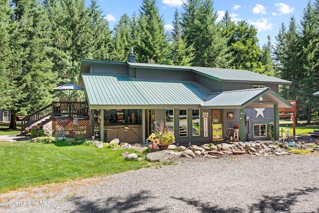 3470 W Seasons Rd, Rathdrum, ID 83858 - view of front of house with metal roof, a hot tub, a front yard, and a wooden deck