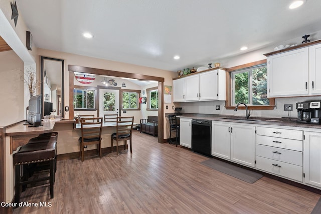 3470 W Seasons Rd, Rathdrum, ID 83858 - kitchen with black dishwasher, a sink, dark countertops, light wood finished floors, and recessed lighting