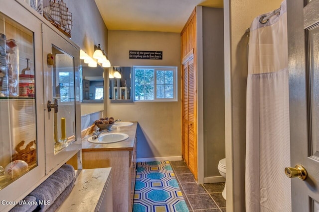 348 Kootenai Trail Rd, Naples, ID 83847 - full bathroom featuring double vanity, toilet, tile patterned flooring, and baseboards