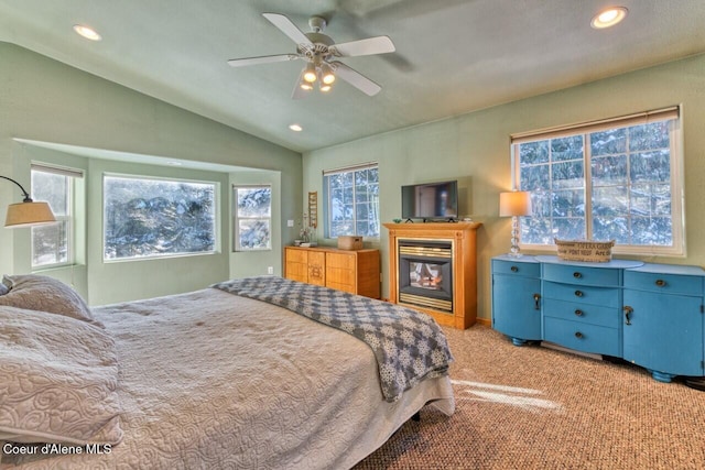 348 Kootenai Trail Rd, Naples, ID 83847 - bedroom with lofted ceiling, recessed lighting, a glass covered fireplace, light colored carpet, and a ceiling fan