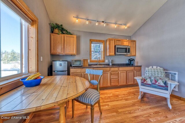 348 Kootenai Trail Rd, Naples, ID 83847 - kitchen featuring stainless steel appliances, vaulted ceiling, track lighting, light wood finished floors, and a sink