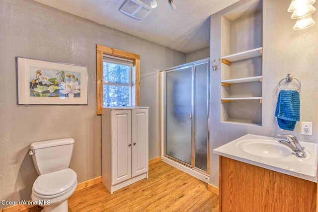 348 Kootenai Trail Rd, Naples, ID 83847 - bathroom with wood finished floors, a stall shower, vanity, and toilet