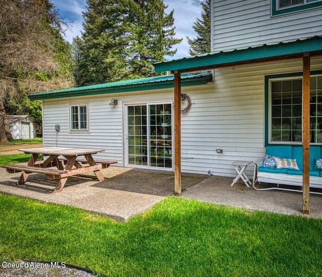 348 Kootenai Trail Rd, Naples, ID 83847 - rear view of house featuring a patio, metal roof, a yard, and outdoor dining space