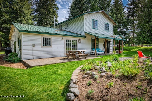 348 Kootenai Trail Rd, Naples, ID 83847 - rear view of house with a patio area, a yard, and metal roof