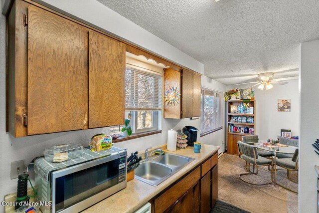 2707-2709 N 10th St, Coeur Dalene, ID 83815 - kitchen with a sink, stainless steel microwave, light countertops, a textured ceiling, and a ceiling fan