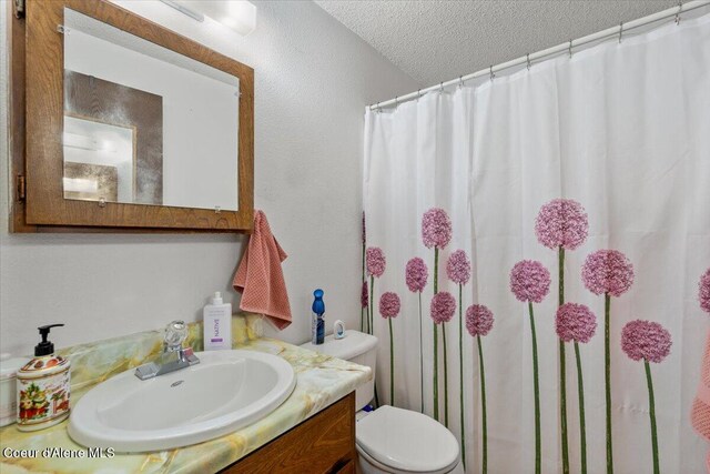 2707-2709 N 10th St, Coeur Dalene, ID 83815 - bathroom with toilet, vanity, a textured ceiling, and a shower with shower curtain