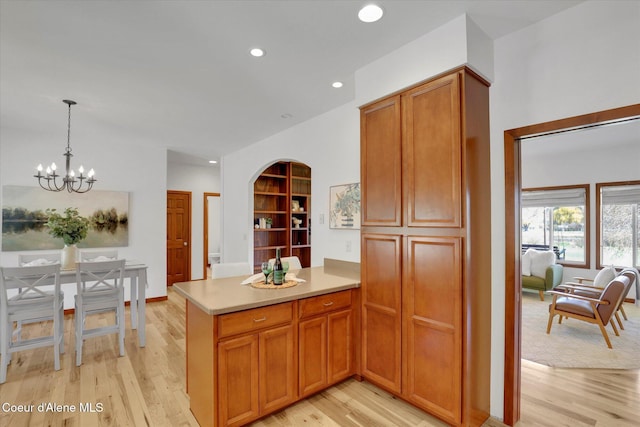 320 S River St, Rockford, WA 99030 - kitchen featuring light wood-type flooring, a chandelier, light countertops, a peninsula, and pendant lighting