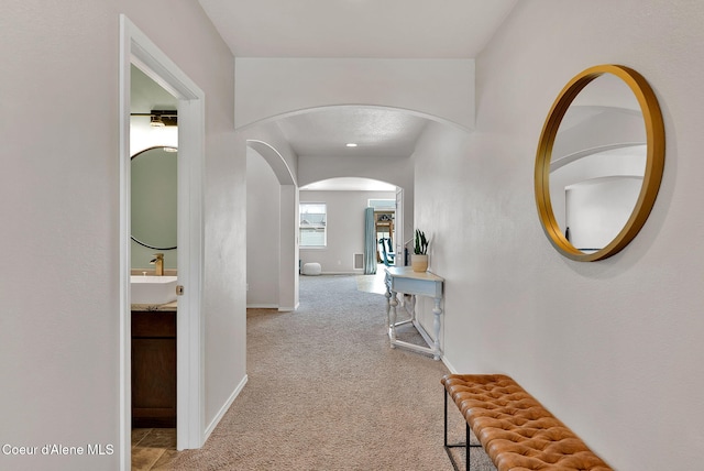 6314 Irish Dr, Rathdrum, ID 83858 - hall with arched walkways, a sink, carpet flooring, and baseboards