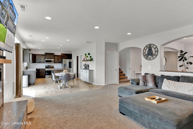 6314 Irish Dr, Rathdrum, ID 83858 - living area featuring arched walkways, light carpet, recessed lighting, stairs, and baseboards
