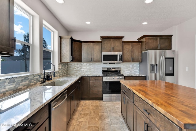 6314 Irish Dr, Rathdrum, ID 83858 - kitchen with appliances with stainless steel finishes, a sink, butcher block countertops, decorative backsplash, and recessed lighting