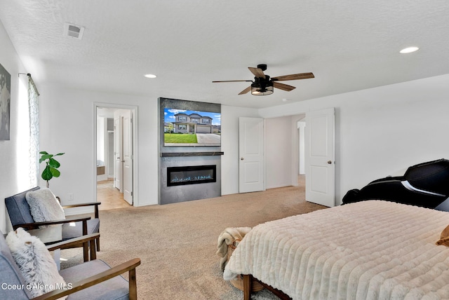 6314 Irish Dr, Rathdrum, ID 83858 - bedroom featuring a glass covered fireplace, light carpet, recessed lighting, baseboards, and a textured ceiling