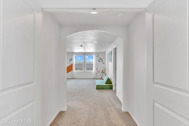 6314 Irish Dr, Rathdrum, ID 83858 - corridor featuring arched walkways, carpet flooring, baseboards, and a textured ceiling