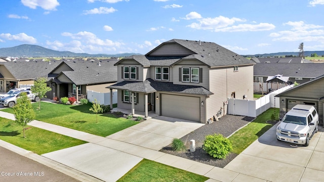 6314 Irish Dr, Rathdrum, ID 83858 - view of front facade with driveway, a residential view, a garage, a shingled roof, and a mountain view