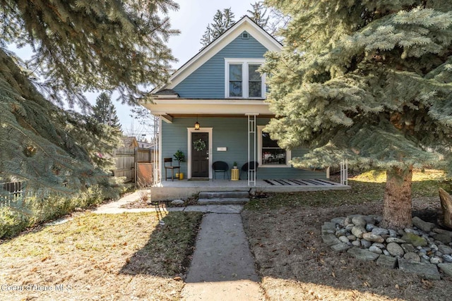 view of front of property featuring covered porch and a gate